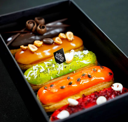 Assorted eclair cream puffs choux by little black pastry box. Vanilla raspberry, passionfruit mango, pandan kaya, chocolate and coffee hazelnut cream eclairs. Eclair Delivery PJ, Subang, KL, Malaysia.